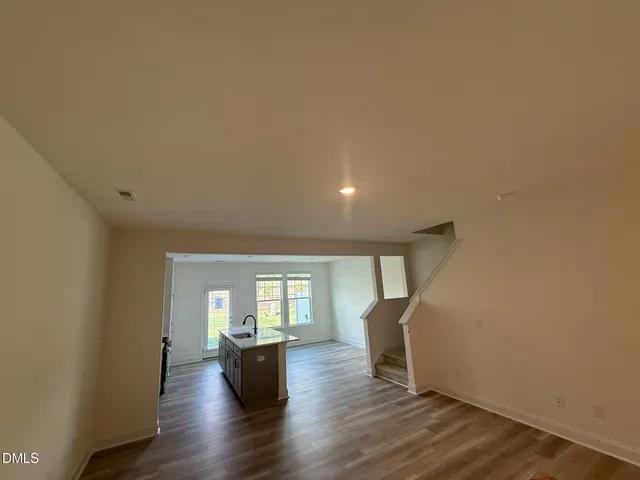 a view of empty room with wooden floor and fireplace