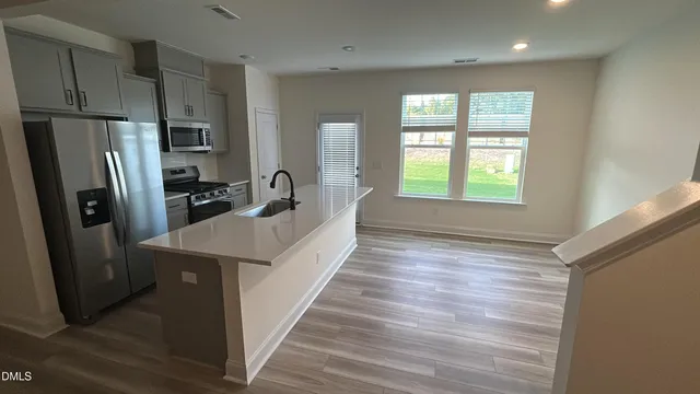a kitchen with stainless steel appliances a refrigerator a sink a stove and cabinets