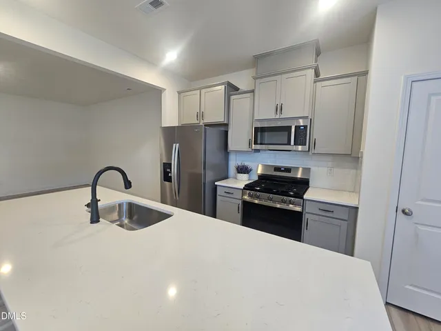 a kitchen with refrigerator a microwave and cabinets