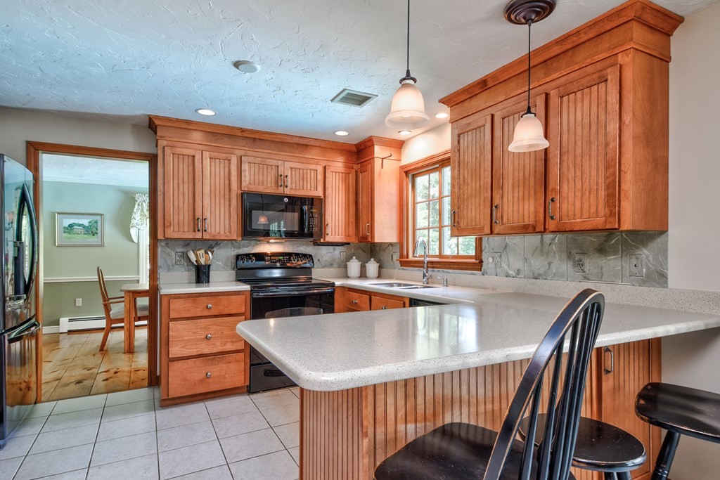 6 Dale Road Hopkinton, MA 01748 - Photo 14 of 39 a kitchen with a table chairs microwave and cabinets