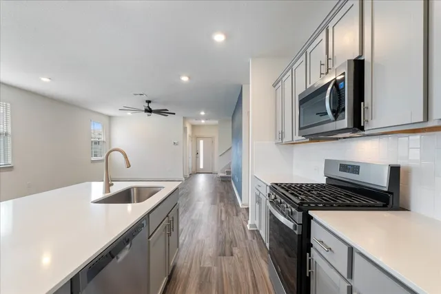 a kitchen with stainless steel appliances granite countertop a sink stove and microwave