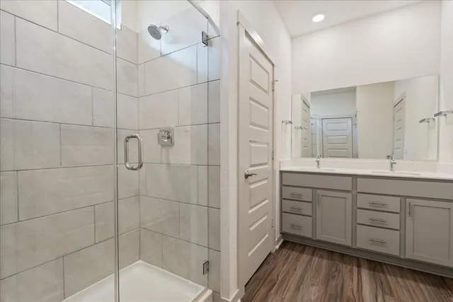 a spacious bathroom with a shower a sink and mirror
