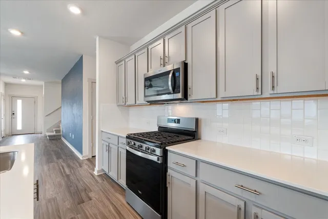 a kitchen with granite countertop a sink a stove and cabinets