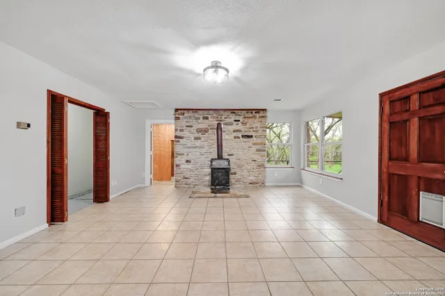 a view of an empty room with a fireplace and a window