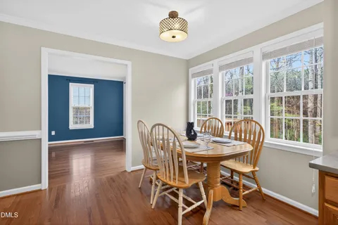 a dining room with furniture a chandelier and wooden floor