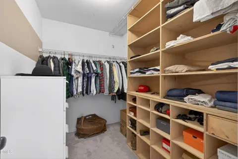 a view of walk in closet with clothes and shoes