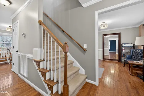 a view of a hallway with wooden floor and staircase