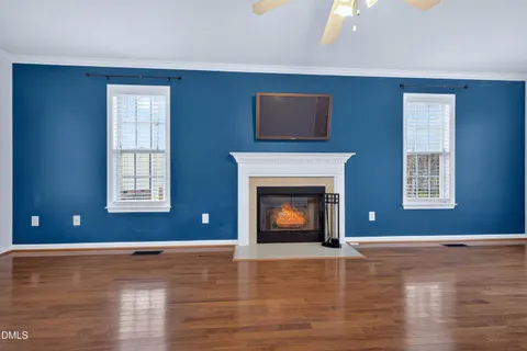 a view of an empty room with window and fire place