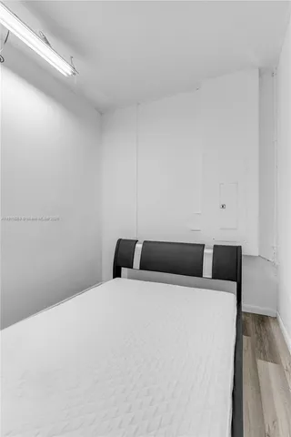 a room with a bed and wooden floor