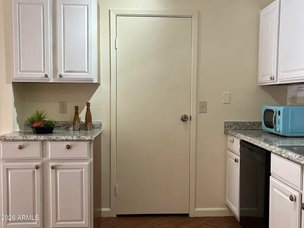 a kitchen with stainless steel appliances granite countertop white cabinets and a refrigerator