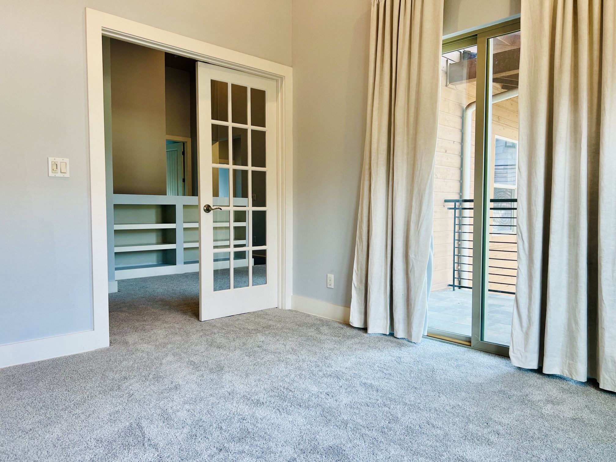 8110 Southeast Ranch Road 2222, Unit 98 Austin, TX 78730 - Photo 14 of 31 Sliding glass doors open to a private balcony from this carpeted bedroom suite.