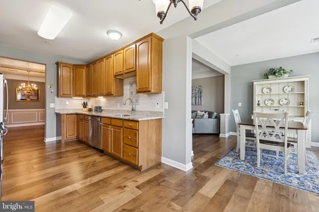 a kitchen with stainless steel appliances kitchen island granite countertop a stove a sink a dining table and chairs