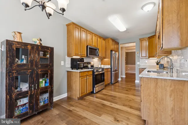 a kitchen with stainless steel appliances granite countertop a refrigerator stove and sink