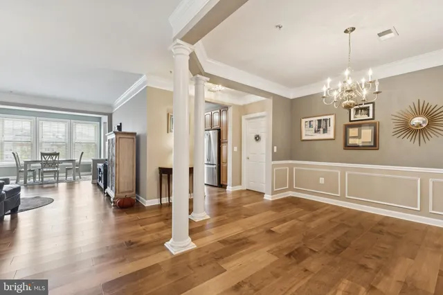 a view of a livingroom with a furniture wooden floor chandelier and windows