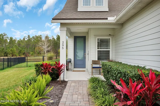 a front view of a house with a yard and potted plants