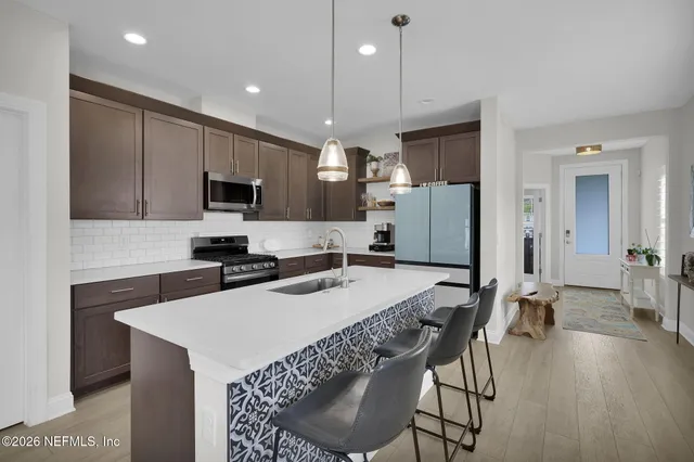 a kitchen with a sink stove top oven and refrigerator