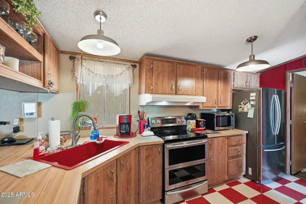 a kitchen with kitchen island granite countertop a sink stainless steel appliances and cabinets