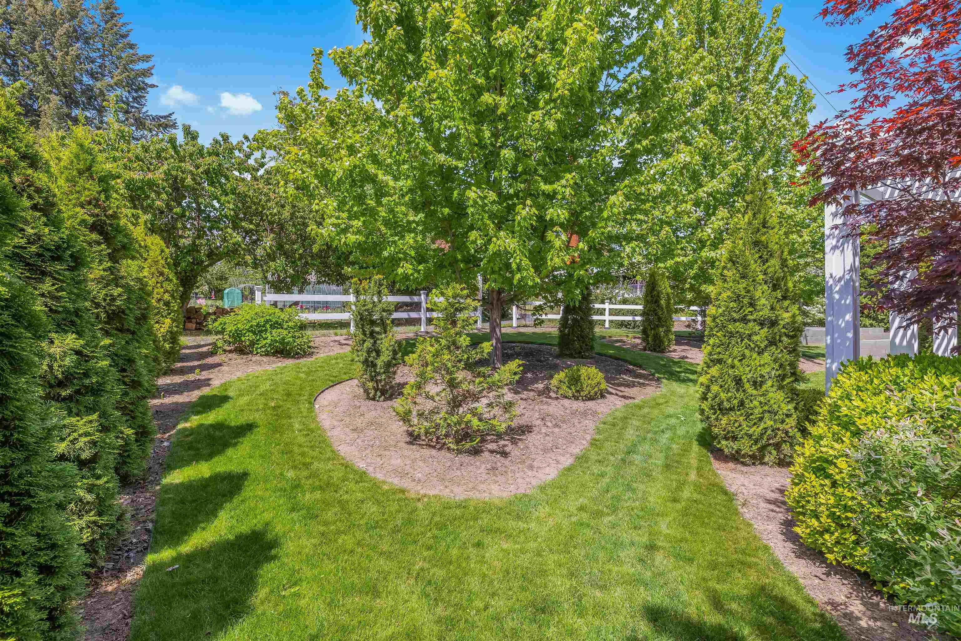 1617 Pine Cone Road Moscow, ID 83843 - Photo 36 of 44 Manicured lawn with a winding grass pathway, bordered by mature trees and varied shrubbery