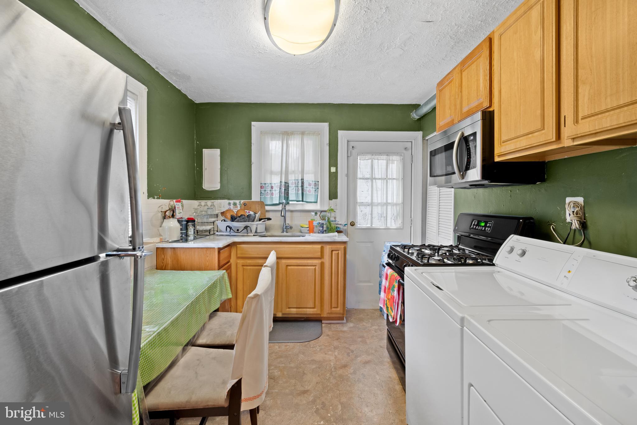 4410 Allies Road Suitland, MD 20746 - Photo 23 of 30 a kitchen with sink a refrigerator and white cabinets