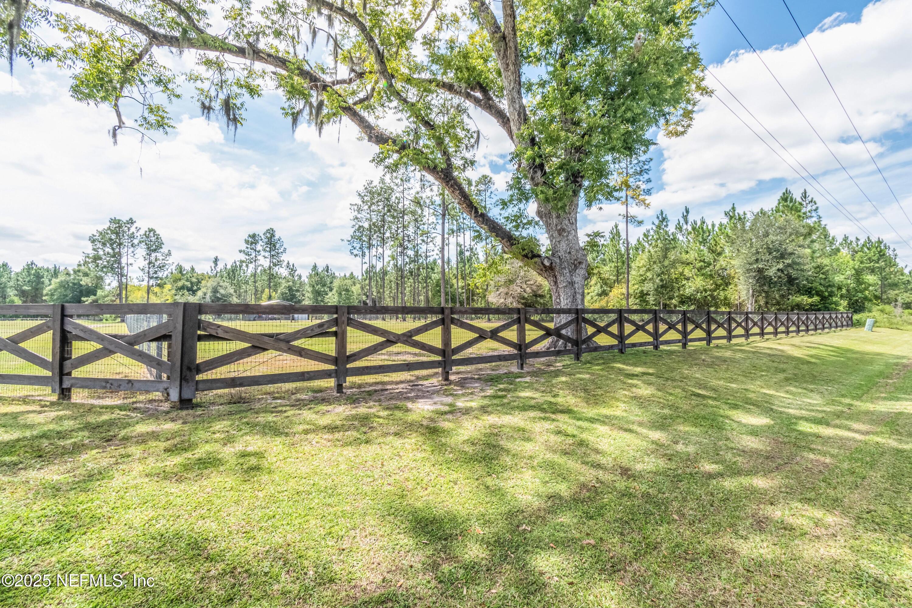 9100 Mud Lake Road Macclenny, FL 32063 - Photo 20 of 25 a view of a swimming pool with a yard and a bench
