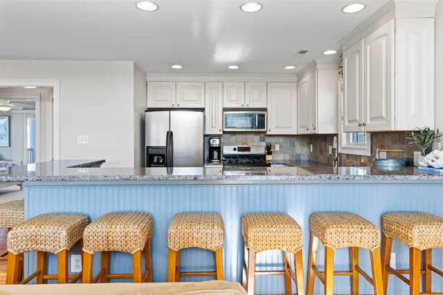 a kitchen with two chairs and refrigerator