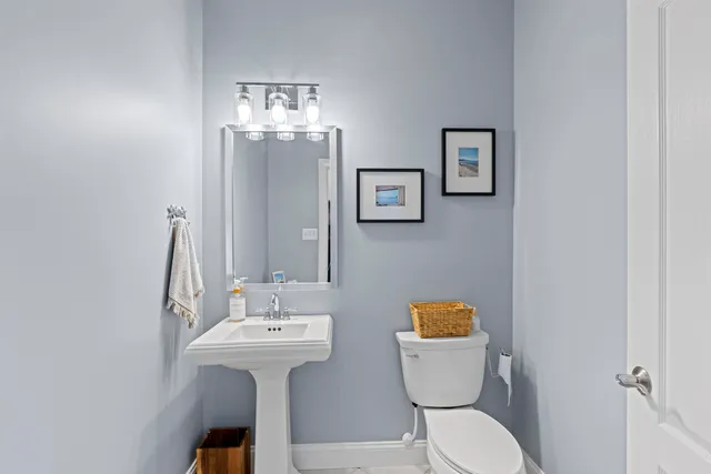 a bathroom with a toilet sink and mirror