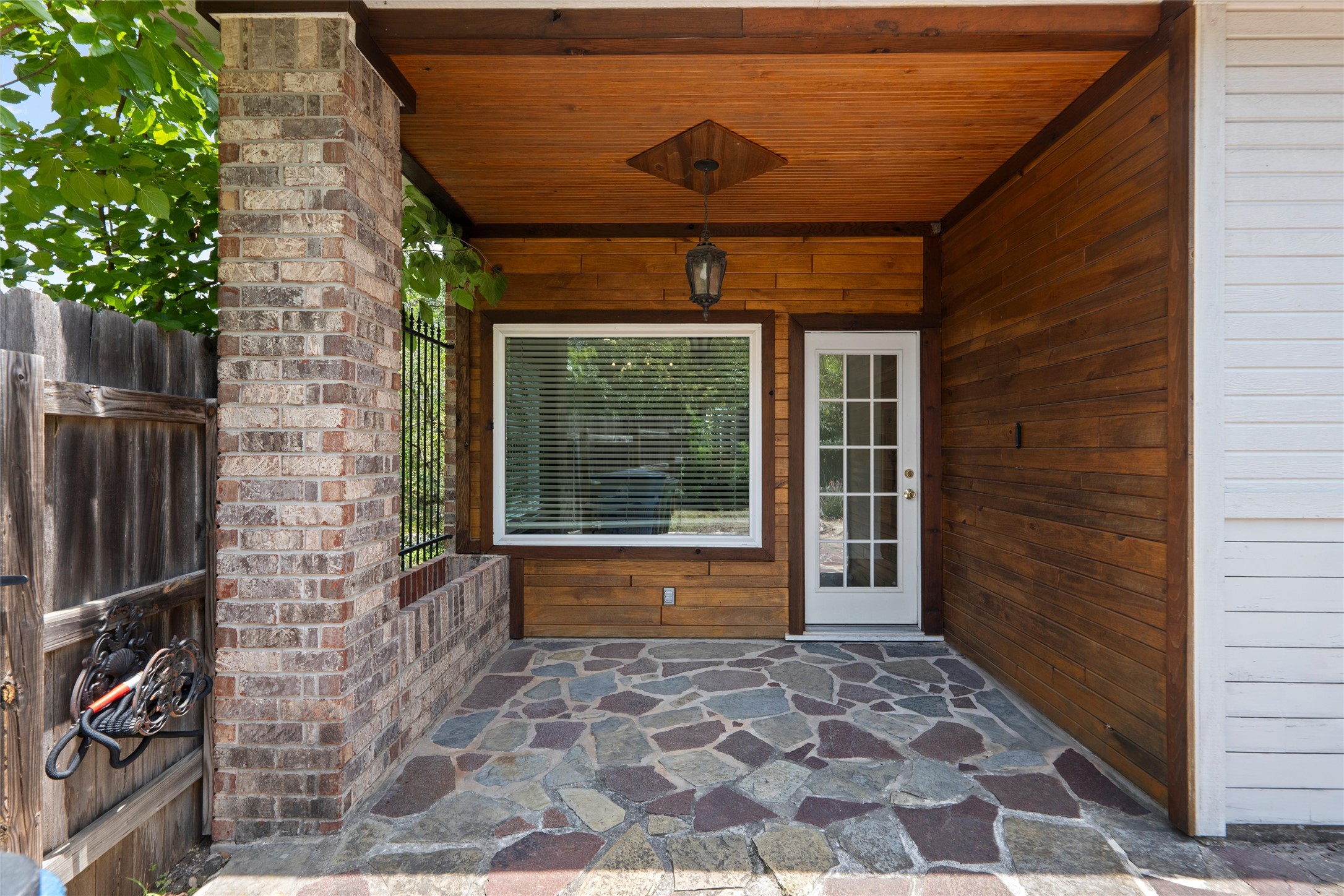 7000 Colberg Court Austin, TX 78749 - Photo 35 of 40 A welcoming front patio with rich wood paneling and varied stone flooring invites outdoor enjoyment.