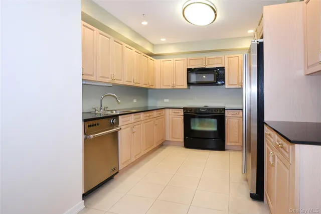 a kitchen with stainless steel appliances granite countertop a stove sink and cabinets