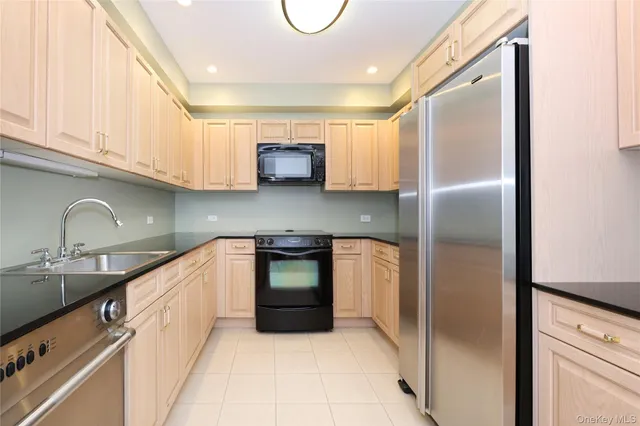 a kitchen with stainless steel appliances granite countertop a refrigerator and a sink
