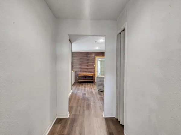 a view of a hallway with wooden floor and a livingroom