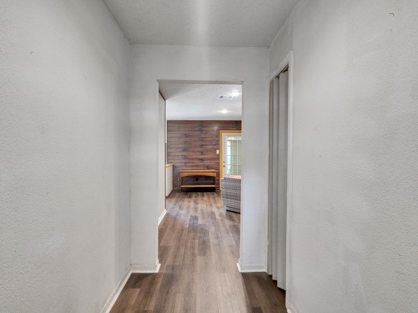 634 Bright Penny Lane Houston, TX 77015 - Photo 14 of 24 a view of a hallway with wooden floor and a livingroom
