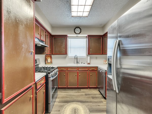 634 Bright Penny Lane Houston, TX 77015 - Photo 7 of 24 a kitchen with stainless steel appliances granite countertop a sink stove and refrigerator