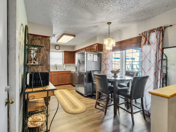 a dining room with furniture a chandelier and wooden floor