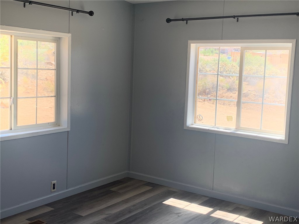 4745 Smoketree Road Golden Valley, AZ 86413 - Photo 22 of 33 a view of an empty room with wooden floor and a window
