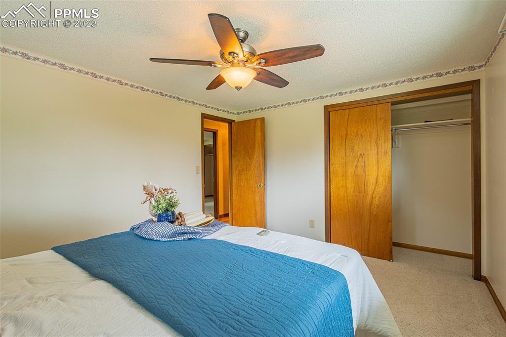 98 Button Rock Road Lyons, CO 80540 - Photo 15 of 49 a bedroom that has a bed and a chandelier fan