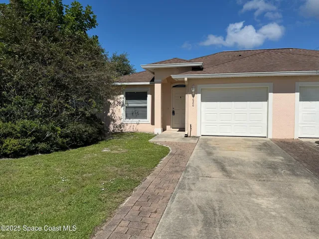 a view of a house with a yard and garage