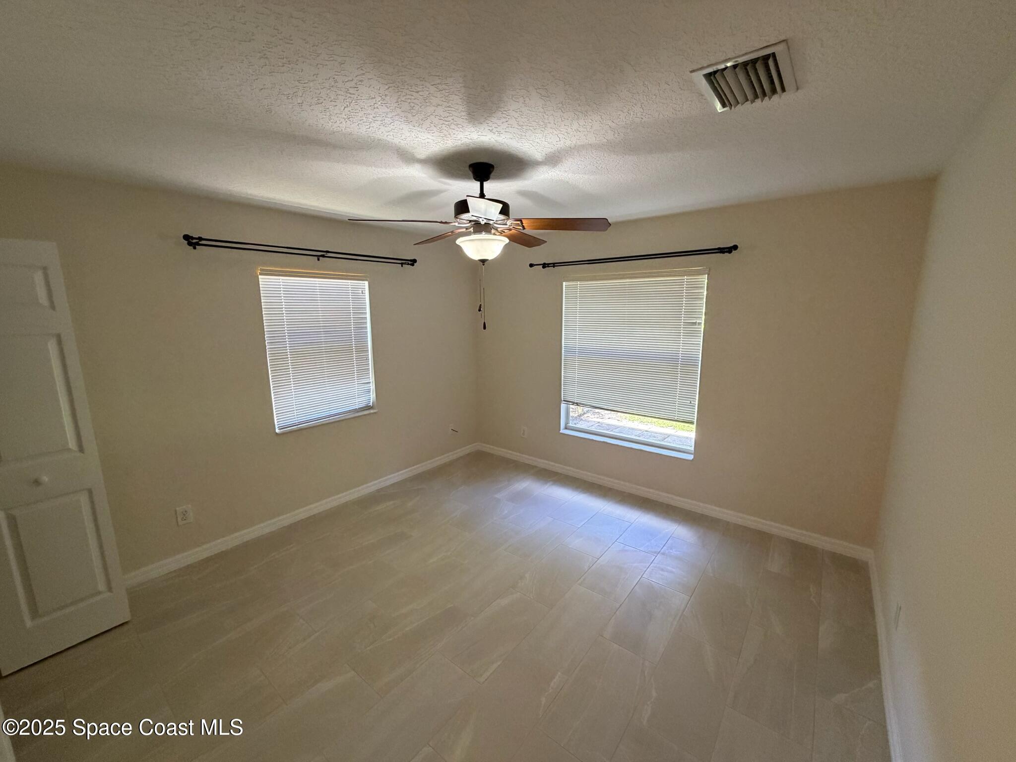 1626 Mason Terrace Melbourne, FL 32935 - Photo 14 of 24 a view of a livingroom with a ceiling fan and window