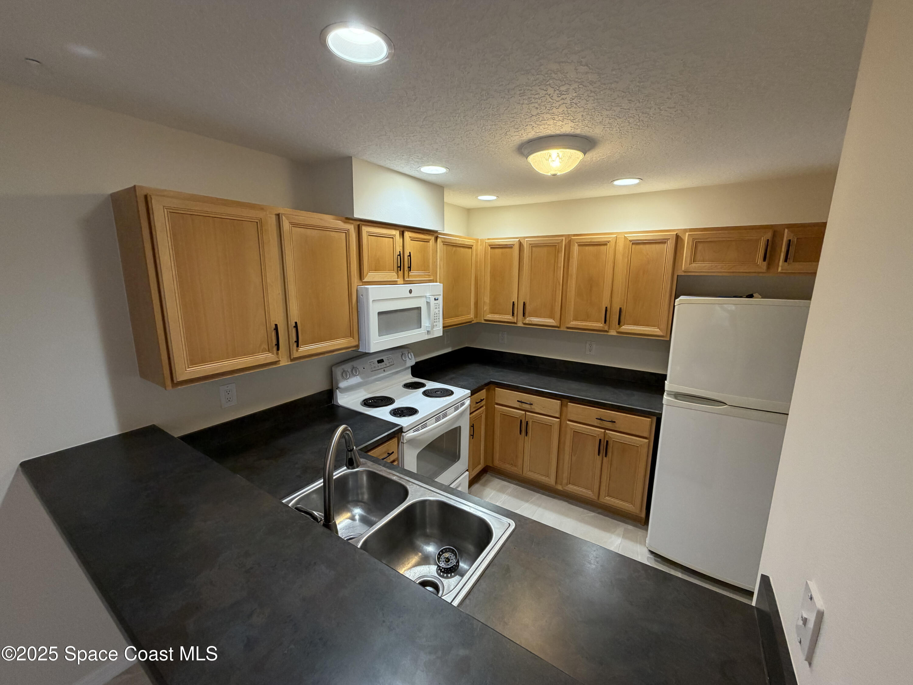 1626 Mason Terrace Melbourne, FL 32935 - Photo 5 of 24 a kitchen with sink refrigerator and stove
