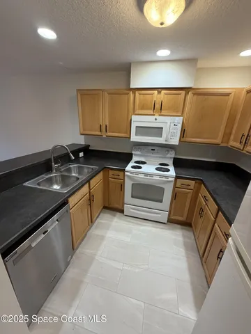 a kitchen with granite countertop a sink and a stove