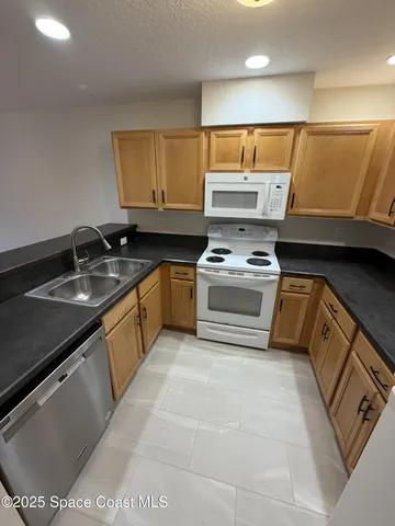 a kitchen with stainless steel appliances granite countertop a sink and a stove
