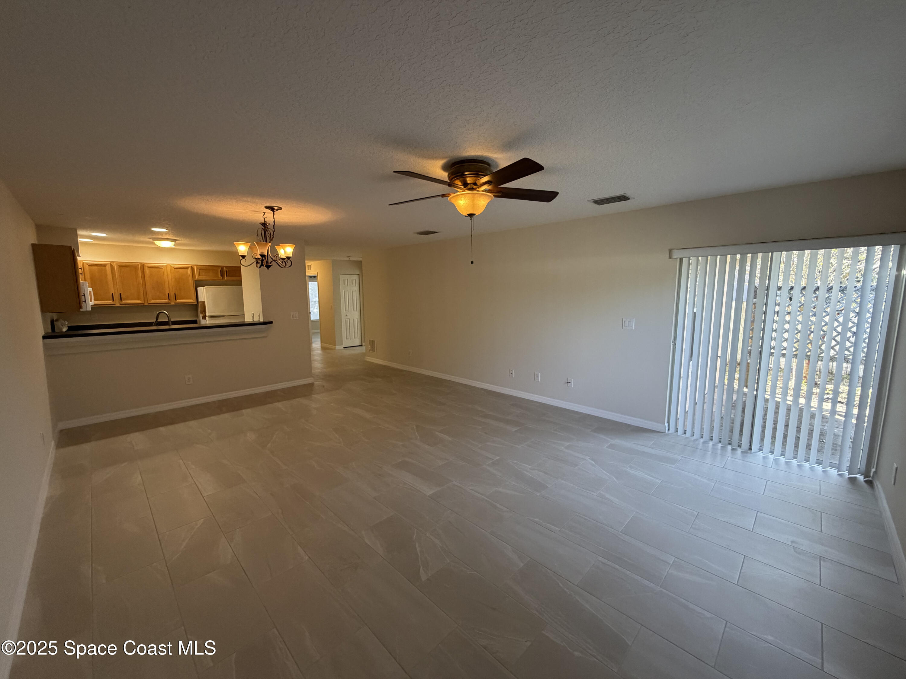 1626 Mason Terrace Melbourne, FL 32935 - Photo 10 of 24 en empty room with windows and ceiling fan