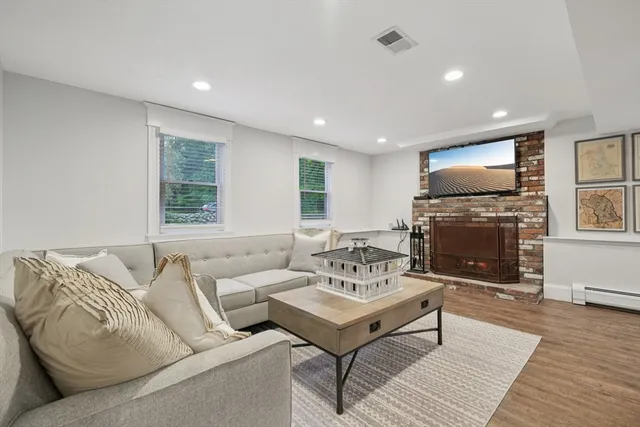 a living room with furniture a fireplace and a flat screen tv