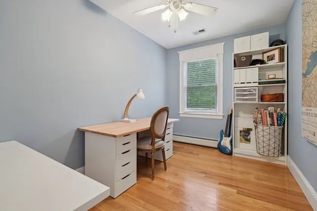 a view of a workspace with furniture and a window
