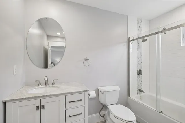 a bathroom with a granite countertop toilet sink and shower