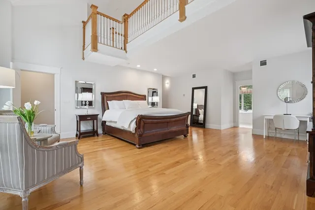 a spacious bedroom with a bed and wooden floor