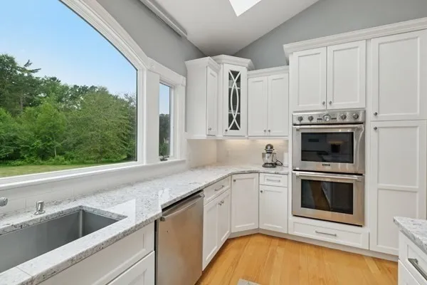 a kitchen with granite countertop a sink and stove top oven