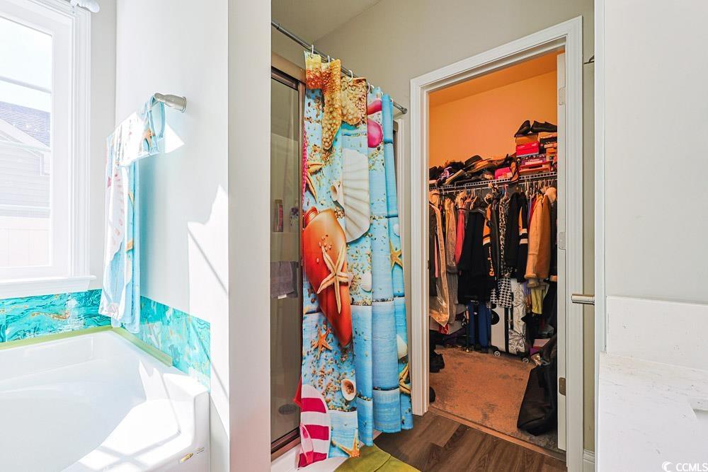 724 Hobonny Loop Longs, SC 29568 - Photo 16 of 40 Bathroom with a shower stall, a spacious closet, a bath, and wood finished floors