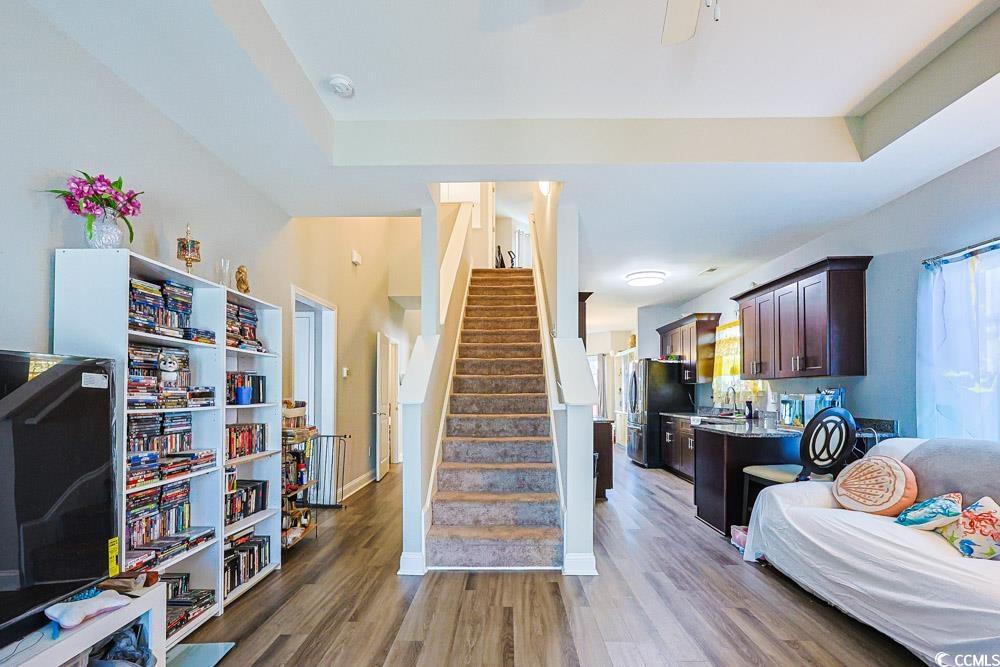 724 Hobonny Loop Longs, SC 29568 - Photo 4 of 40 Kitchen with dark brown cabinetry, dark wood finished floors, freestanding refrigerator, a tray ceiling, and light stone countertops