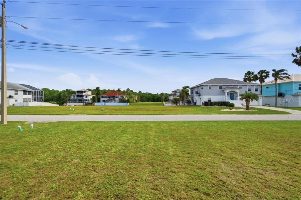 3487 Croaker Drive Hernando Beach, FL 34607 - Photo 7 of 27 a view of building with garden and tall trees in the background