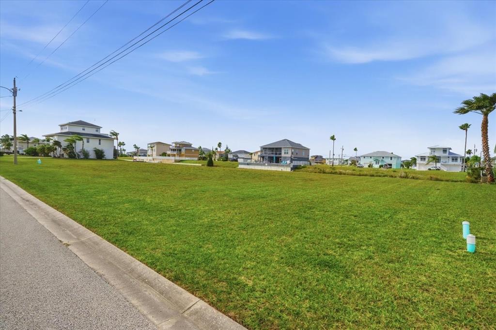 3487 Croaker Drive Hernando Beach, FL 34607 - Photo 10 of 27 a view of a field with lawn chairs and large trees